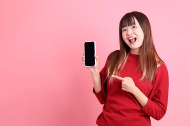 Çin Yeni Yılı, pembe arka planda el ele tutuşurken işaret eden kırmızı tişörtlü Asyalı kadın. Gen Z