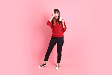 Mutlu Çin Yeni Yılı, pembe arka planda el ele tutuşan kırmızı, sıradan tişörtlü, Asyalı bir kadın. Gen Z