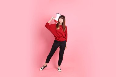 Mutlu Çin Yeni Yılı, kırmızı günlük tişörtlü Asyalı kadın bağırma jesti, pembe arka planda izole edilmiş megafon taşıyor. Gen Z