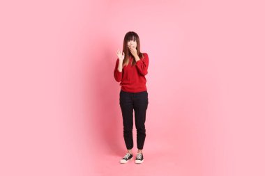 Mutlu Çin Yeni Yılı, kırmızı, sıradan tişörtlü Asyalı bir kadın sürpriz jesti ve pembe arka planda etkileyici bir izolasyon. Gen Z