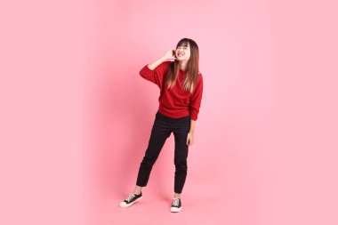 Mutlu Çin Yeni Yılı, kırmızı günlük tişörtlü Asyalı kadın kalp şeklinde jestler, küçük kalp, pembe arka planda izole edilmiş aşk. Gen Z