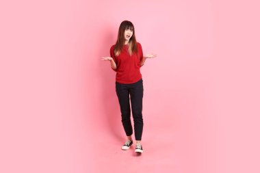 Mutlu Çin Yeni Yılı, kırmızı günlük tişörtlü Asyalı genç bir bayan. Acıma jesti. Üzgünüm, pembe arka planda pek bir şey yok. Gen Z