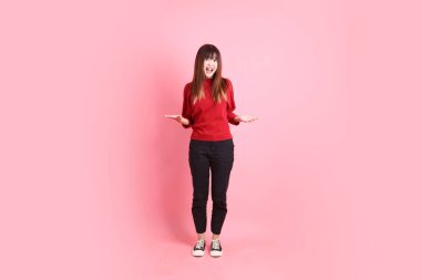 Mutlu Çin Yeni Yılı, kırmızı günlük tişörtlü Asyalı genç bir bayan. Acıma jesti. Üzgünüm, pembe arka planda pek bir şey yok. Gen Z