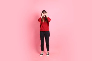 Mutlu Çin Yeni Yılı, kırmızı günlük tişörtlü Asyalı genç bayan baş parmak işareti ile, tamam ya da pembe arka planda izole edilmiş. Gen Z