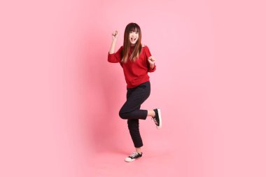 Mutlu Çin Yeni Yılı, pembe arka planda izole edilmiş dans jesti ile kırmızı günlük Asyalı kadın tişörtü. Gen Z