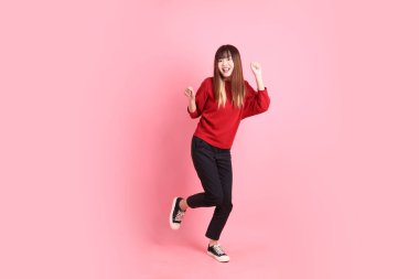 Mutlu Çin Yeni Yılı, pembe arka planda izole edilmiş dans jesti ile kırmızı günlük Asyalı kadın tişörtü. Gen Z