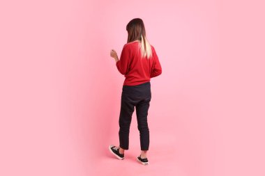 Mutlu Çin Yeni Yılı, pembe arka planda izole edilmiş yürüme jesti ile kırmızı günlük Asyalı kadın tişörtü. Gen Z