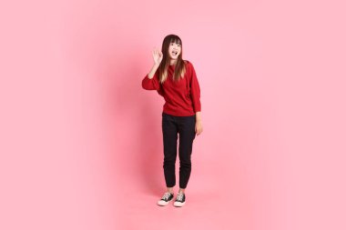 Mutlu Çin Yeni Yılı, kırmızı, sıradan tişörtlü Asyalı bir kadın Çin usulü selamlama jesti, pembe arka planda izole edilmiş davetiye. Gen Z