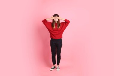 Mutlu Çin Yeni Yılı, kırmızı günlük tişörtlü Asyalı genç bir kadın pembe arka planda izole edilmiş gizli gözler jesti. Gen Z