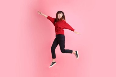 Mutlu Çin Yeni Yılı, kırmızı günlük tişörtlü Asyalı kadın evet jesti, heyecanlı, pembe arka planda izole edilmiş kutlamayı kutluyor. Gen Z