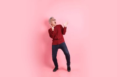 Mutlu Çin Yeni Yılı, resmi ve sıradan kırmızı tişörtlü Asyalı son sınıf öğrencisi sürpriz bir jest ve pembe arka planda etkileyici bir izolasyon..