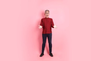 Mutlu Çin Yeni Yılı, resmi ve sıradan kırmızı tişörtlü Asyalı son sınıf öğrencisi sürpriz bir jest ve pembe arka planda etkileyici bir izolasyon..