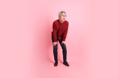 Mutlu Çin Yeni Yılı, resmi ve sıradan kırmızı tişörtlü Asyalı son sınıf öğrencisi yorgun, depresif ya da tembel ve pembe arka planda soyutlanmış..