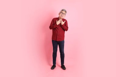 Mutlu Çin Yeni Yılı, resmi ve sıradan kırmızı tişörtlü Asyalı son sınıf öğrencisi pembe arka planda hastalıklı davranışlar sergiliyor..