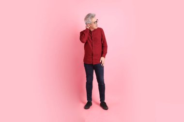 Mutlu Çin Yeni Yılı, resmi ve sıradan kırmızı tişörtlü Asyalı son sınıf öğrencisi pembe arka planda hastalıklı davranışlar sergiliyor..