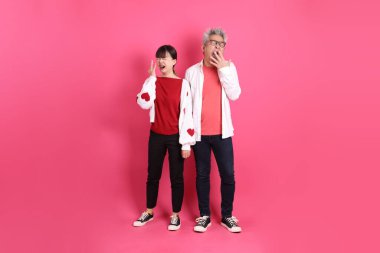 Sevgililer Günü 'nde, Asyalı son sınıf öğrencisi ve genç kadın pembe arka planda uykulu ya da esnemiş gibi duran beyaz kalp şeklinde gömlekli sıradan kırmızı kıyafetler giyerler..