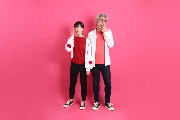 Sevgililer Günü 'nde, Asyalı son sınıf öğrencisi ve genç kadın pembe arka planda uykulu ya da esnemiş gibi duran beyaz kalp şeklinde gömlekli sıradan kırmızı kıyafetler giyerler..