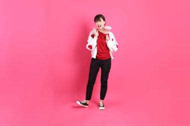 Sevgililer Günü, kırmızı tişörtlü Asyalı bir kadın ya da günlük kıyafetler, kırmızı kalp şeklinde gömlek ve pembe arka planda saklanmış çiçekleri tutan bir jest. Gen Z