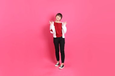 Sevgililer günü, kırmızı tişörtlü Asyalı bir kadın ya da günlük kıyafetler, kırmızı kalp şeklinde, baş parmak işareti olan bir gömlek, tamam ya da pembe arka planda izole edilmiş. Gen Z