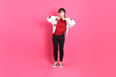 Sevgililer günü, kırmızı tişörtlü Asyalı bir kadın ya da günlük kıyafetler, kırmızı kalp şeklinde bir gömlek, dur, yasakla, reddet şeklinde bir jest, pembe arka planda izole edilmemiş. Gen Z