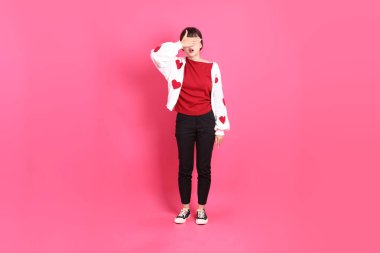 Sevgililer Günü, kırmızı tişörtlü Asyalı bir kadın ya da günlük kıyafetler, pembe arka planda kapalı gözlerden oluşan kırmızı kalp şeklinde bir gömlek. Gen Z