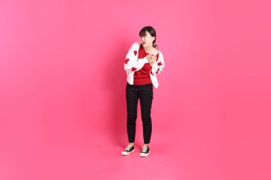 Sevgililer Günü, kırmızı tişörtlü Asyalı bir kadın ya da günlük kıyafetler, pembe arka planda Heartache izole edilmiş kırmızı kalp şeklinde bir gömlek. Gen Z