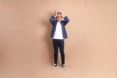 Baş ağrısı jesti ya da esmer arka planda izole edilmiş stres olan Asyalı son sınıf öğrencisi. Turist, akıllı gündelik.