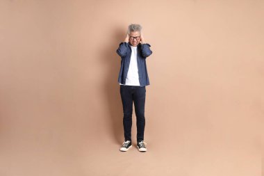 Baş ağrısı jesti ya da esmer arka planda izole edilmiş stres olan Asyalı son sınıf öğrencisi. Turist, akıllı gündelik.