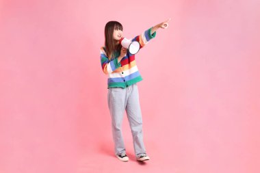 Renkli gökkuşağı kıyafetleri giyen Asyalı bir kadın ya da pembe arka planda megafon tutan bağrışma hareketleriyle sıradan görünen bir kadın. Gen Z