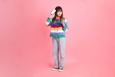 Renkli gökkuşağı kıyafetleri giyen Asyalı bir kadın ya da pembe arka planda megafon tutan bağrışma hareketleriyle sıradan görünen bir kadın. Gen Z