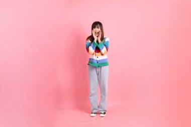 Renkli gökkuşağı kıyafetleri giyen Asyalı bir kadın ya da pembe arka planda megafon tutan bağrışma hareketleriyle sıradan görünen bir kadın. Gen Z