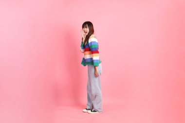 Renkli gökkuşağı kıyafetleri giyen Asyalı bir kadın ya da pembe arka planda megafon tutan bağrışma hareketleriyle sıradan görünen bir kadın. Gen Z