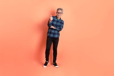 Yeşil ekose giysili Asyalı son sınıf öğrencisi. Gözlük takıyor. Başparmak işareti yapıyor. Turist, akıllı gündelik.