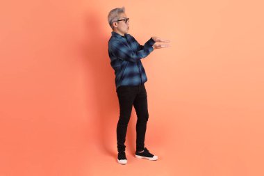 Yeşil ekose giysili Asyalı son sınıf öğrencisi. Gözlük takıyor. Üzerinde Ölçü Sembolü işareti var. Turist, akıllı gündelik.