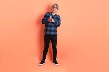 Yeşil ekose giysili Asyalı son sınıf öğrencisi. Gözlük takıyor. Üzerinde Ölçü Sembolü işareti var. Turist, akıllı gündelik.