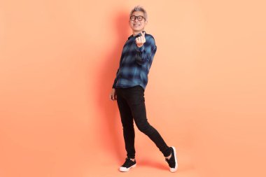 Yeşil ekose elbiseli Asyalı son sınıf öğrencisi. Gözlük takıyor. Kalp şeklinde jestler yapıyor. Turist, akıllı gündelik.