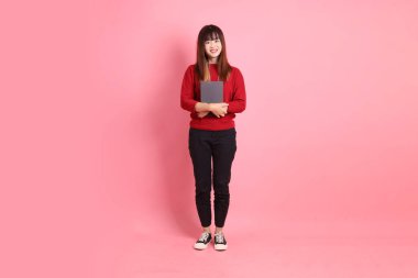 Kırmızı tişörtlü ya da sıradan giysili Asyalı kız öğrenci pembe arka planda okul çantası taşıyor. Gen Z