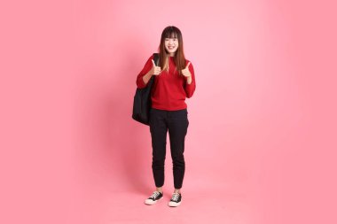 Kırmızı tişörtlü Asyalı kız öğrenci ya da günlük giysiler içinde okul çantası ve kitap taşıyorlar, tamam ya da pembe arka planda izole edilmiş olduklarını onaylıyorlar. Gen Z