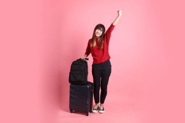 Kırmızı tişörtlü Asyalı kız öğrenci ya da günlük kıyafetler içinde okul çantası ve bavul taşıyorlar. Evet jestleriyle, heyecanlı, pembe arka planda izole edilmiş bir şekilde kutluyorlar. Gen Z