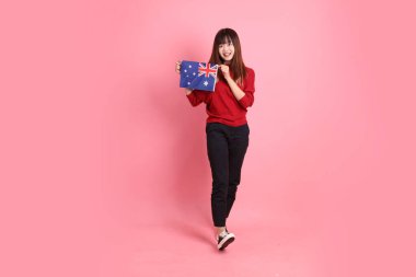 Kırmızı tişörtlü Asyalı kız öğrenci ya da günlük kıyafetler içinde ABD ya da Amerika Birleşik Devletleri ya da pembe arka planda izole edilmiş Amerikan bayrağı taşıyan okul çantası taşıyorlar. Gen Z