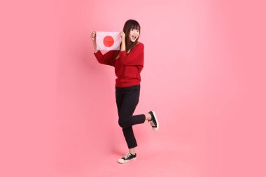 Kırmızı tişörtlü ya da sıradan giysili Asyalı bir kız öğrenci pembe arka planda Japon ya da Japon bayrağı taşıyan bir jestle okul çantası taşıyor. Gen Z