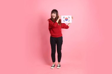 Kırmızı tişörtlü ya da sıradan giysili Asyalı kız öğrenci pembe arka planda Kore ya da Kore bayrağı saklama hareketi içeren okul çantası taşıyor. Gen Z