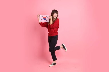 Kırmızı tişörtlü ya da sıradan giysili Asyalı kız öğrenci pembe arka planda Kore ya da Kore bayrağı saklama hareketi içeren okul çantası taşıyor. Gen Z