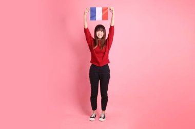 Kırmızı tişörtlü ya da sıradan giysili Asyalı kız öğrenci pembe arka planda Fransız ya da Fransız bayrağı taşıyan okul çantası taşıyor. Gen Z