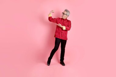 Yeni Çin yılın kutlu olsun. Asya 'nın son sınıf öğrencisi, geleneksel kırmızı Cheongsam Qipao ya da Changshan elbisesi giyiyor. Sağlıklı, güçlü, pembe arka planda izole bir jest..