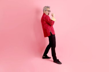 Yeni Çin yılın kutlu olsun. Asya 'nın son sınıf öğrencisi, geleneksel kırmızı Cheongsam Qipao ya da Changshan elbisesi giyiyor. Pembe arka planda izole edilmiş bir dövüş jesti..