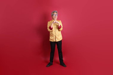 Yeni Çin yılın kutlu olsun. Asyalı Çinli son sınıf öğrencisi altın rengi Cheongsam Qipao ya da Chang Shan elbisesi giyiyor..