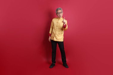 Yeni Çin yılın kutlu olsun. Asyalı Çinli son sınıf öğrencisi altın rengi Cheongsam Qipao ya da Chang Shan elbisesi giyiyor..