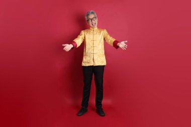 Yeni Çin yılın kutlu olsun. Asya 'nın son sınıf öğrencisi altın rengi Cheongsam Qipao ya da Changshan elbisesi giyiyor. Kırmızı arka planda izole edilmiş bir şekilde verme ve alma jesti..