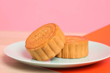 Geleneksel Çin tatlı ay çöreği ya da pembe ve turuncu arka planda Çin pastası. Çin Geleneksel Sonbahar Festivali, Ay Festivali.